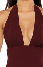 Close-up of the burgundy maxi dress showing the deep V-neckline, ruched bust, and halter straps