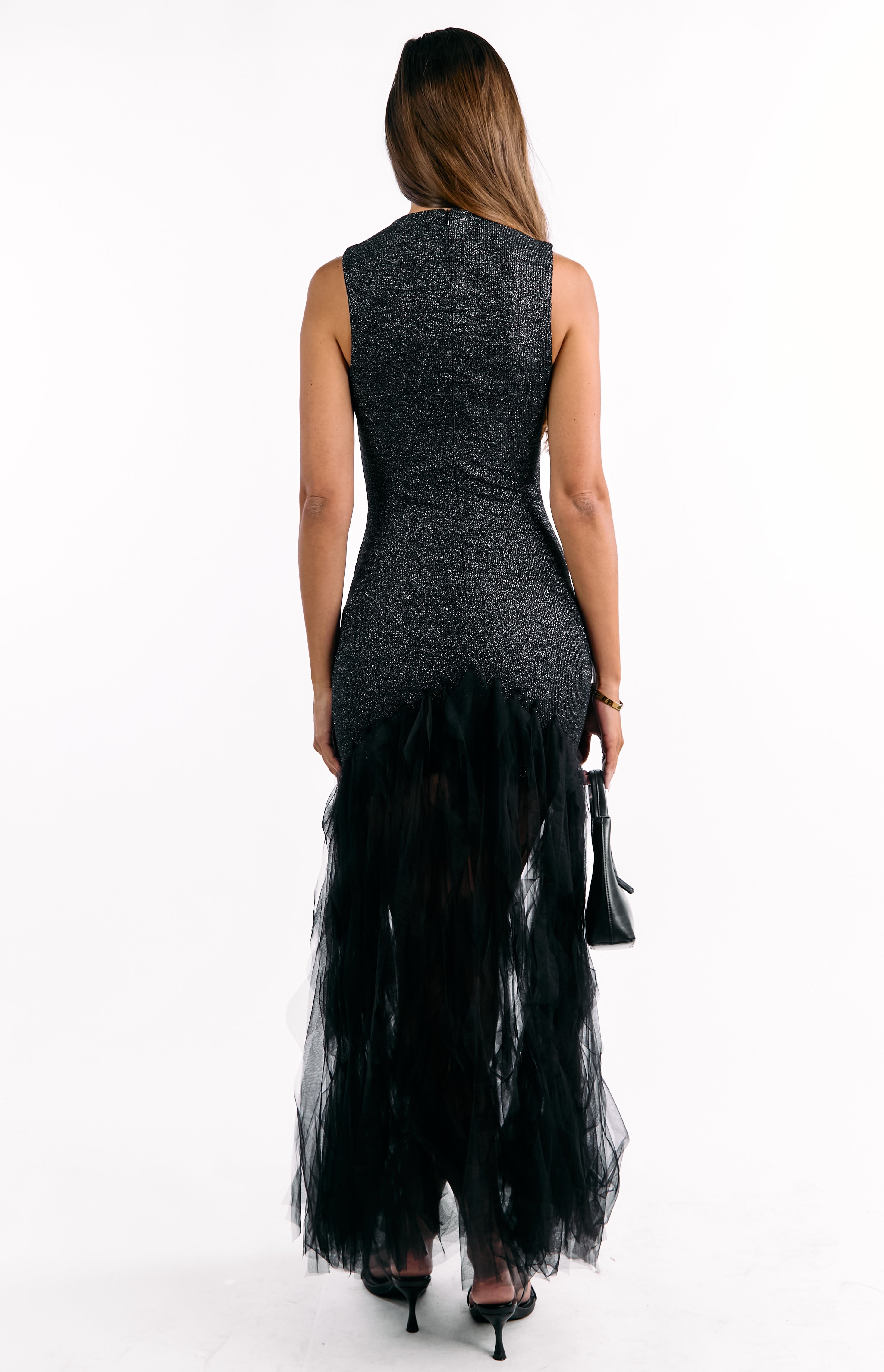 Rear view of a black sequin sleeveless maxi dress with a high back and a voluminous ruffled tulle skirt