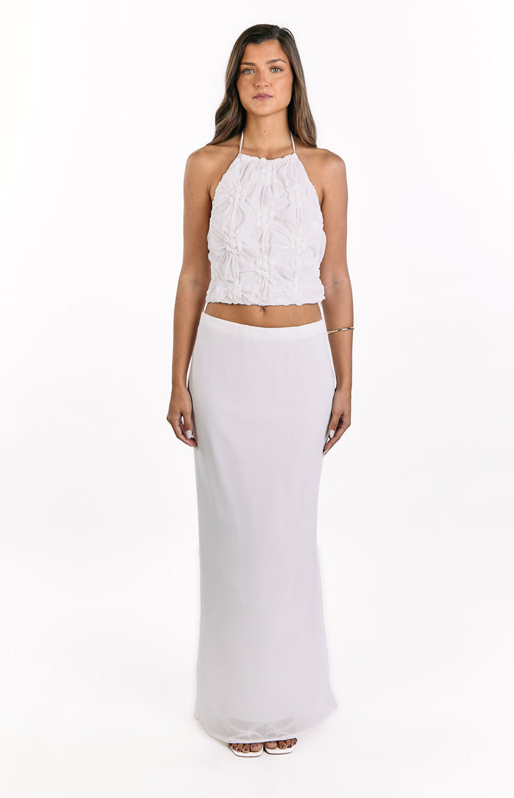 Front view of a white textured halter top with a floral ruched pattern and a cropped hem