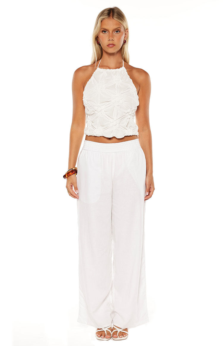 Front view of a white textured halter top with a ruched, gathered bodice and elasticated hem