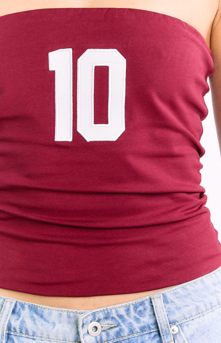 Close-up of the white '10' graphic on the front of the burgundy strapless top with ruched side detail