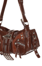 Angled close-up of brown PU shoulder bag with silver hardware, multiple zippers, studs, and crocodile embossed panels
