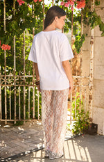 Rear view of white sequin lace sheer pants with a wide leg and full length