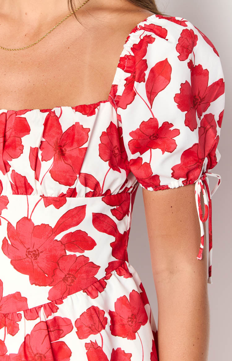 Close-up of the red anemone floral mini dress showing the square neckline, ruched bust, and puff sleeves with tie details