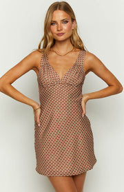 Close-up of the chocolate and white geometric print mini dress showing the gathered V-neck and fitted waist