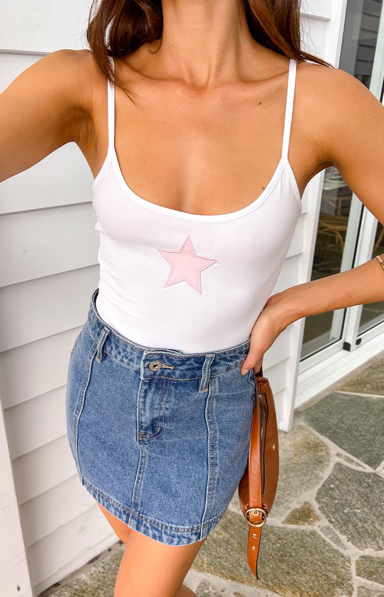 Front view of a mid wash denim high waisted mini skirt with button and zip fly closure