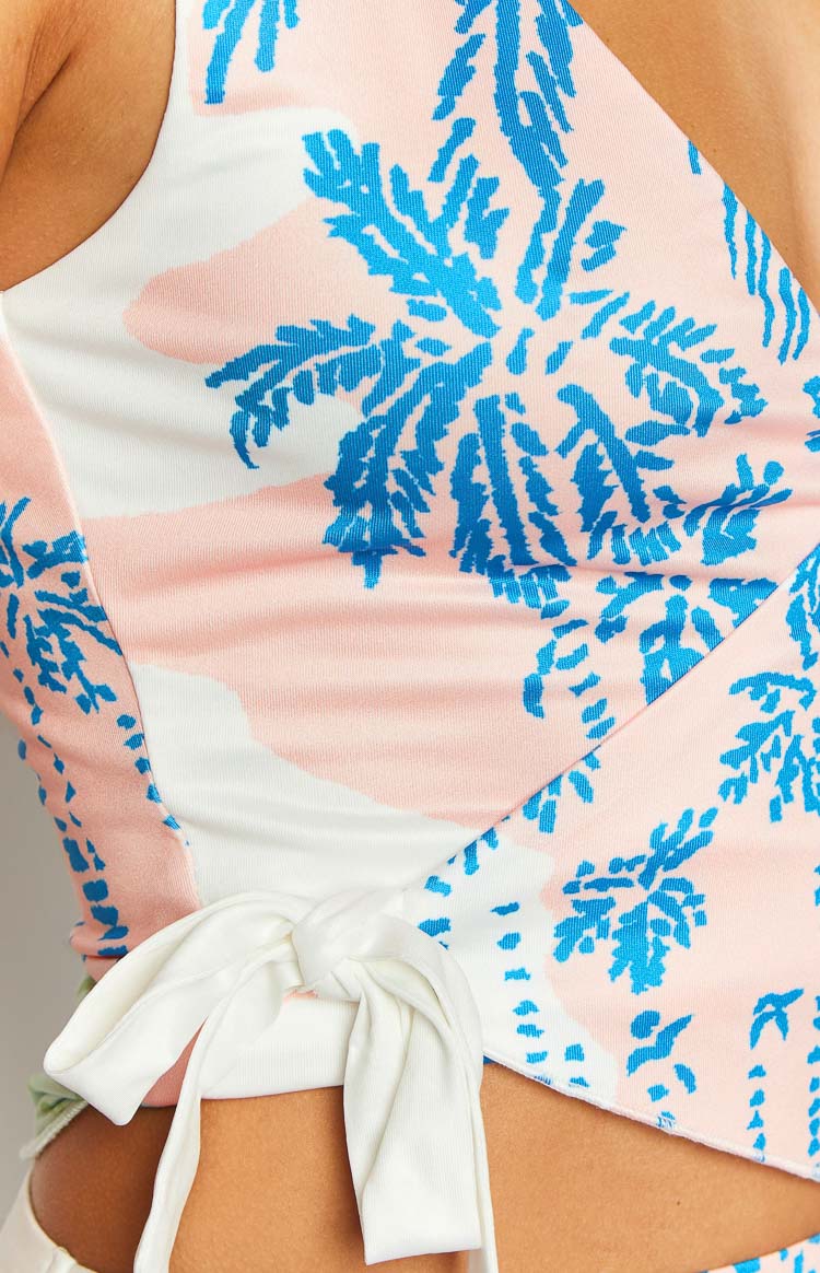 Close-up of the white tie knot detail on the pink and blue palm print top
