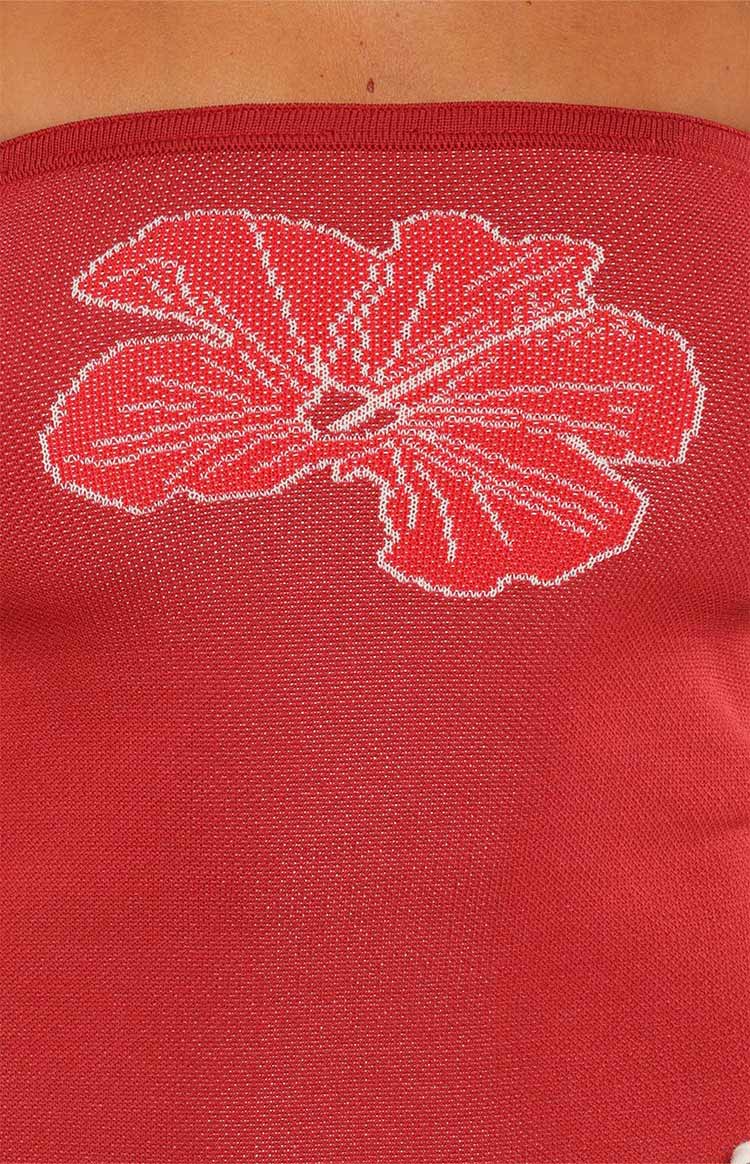 Close-up of the red knit fabric of the tube top, showing the white and red hibiscus pattern and ribbed texture