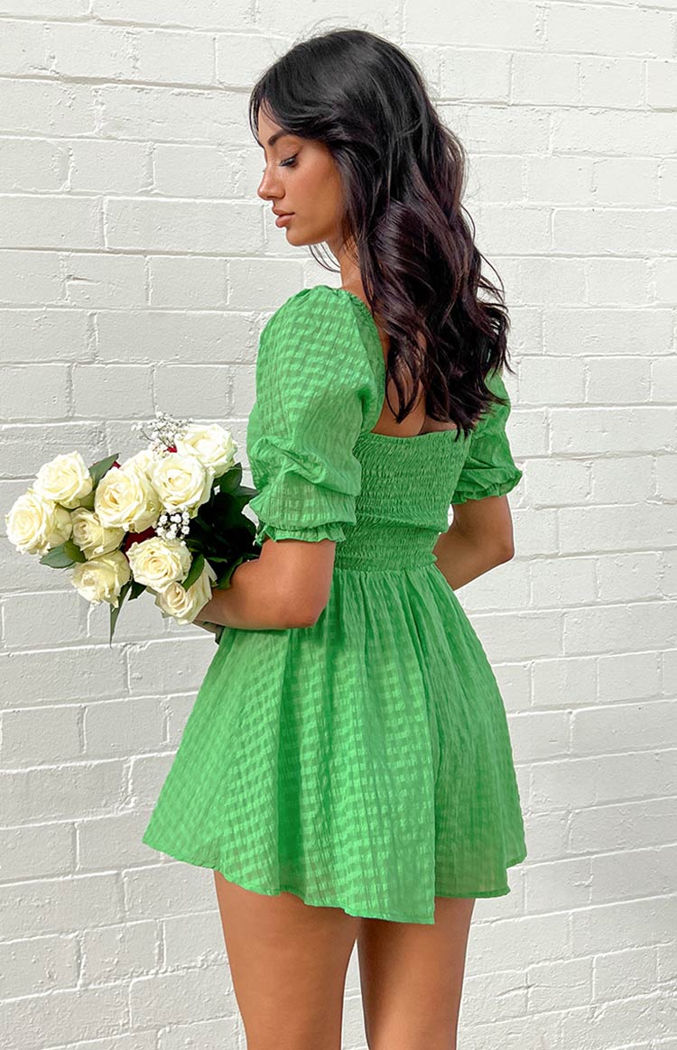 Side view of a green gingham playsuit with puffed short sleeves, square neckline, and shirred waist