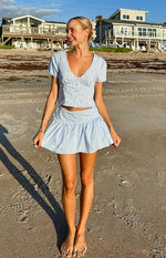 Gathered blue stripe mini skirt with a visible side tie waist and flared hem