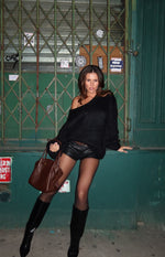 Black chunky knit sweater with an off-shoulder neckline, wide long sleeves, and a relaxed, oversized fit