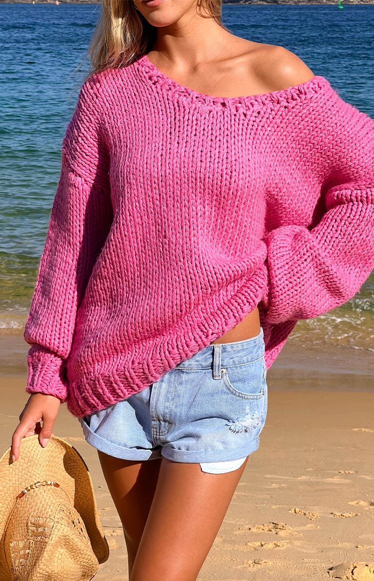 Oversized hot pink chunky knit sweater with a wide V-neckline and ribbed cuffs and hem