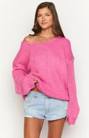 Hot pink chunky knit sweater styled off-shoulder with voluminous sleeves and gathered cuffs