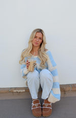 Relaxed fit light blue and cream striped chunky knit sweater with a wide off-shoulder neckline and long sleeves