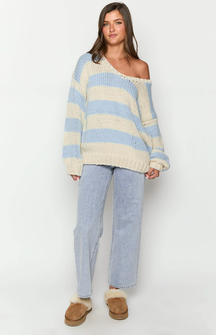 Oversized light blue and cream striped chunky knit sweater with a wide V-neck worn off one shoulder