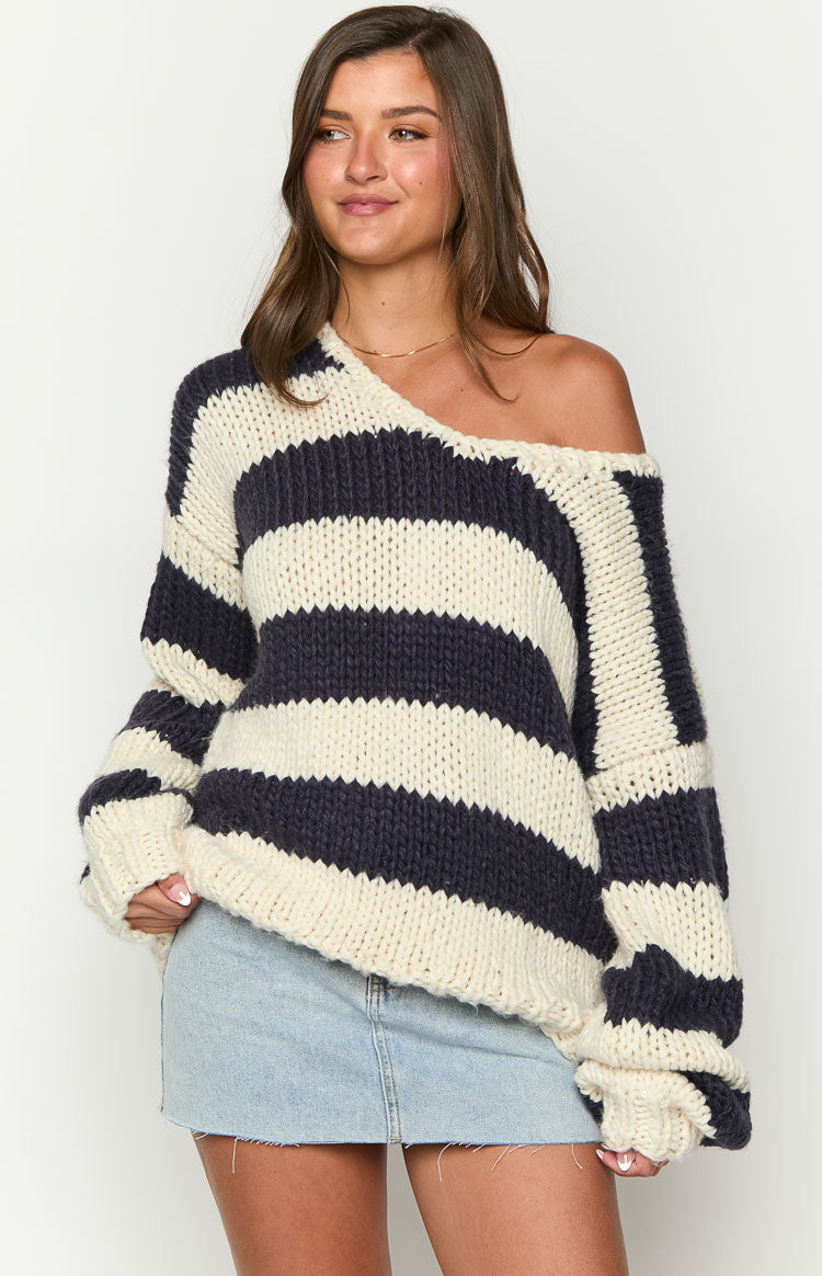 Navy and cream striped chunky knit sweater with a wide neckline worn off one shoulder