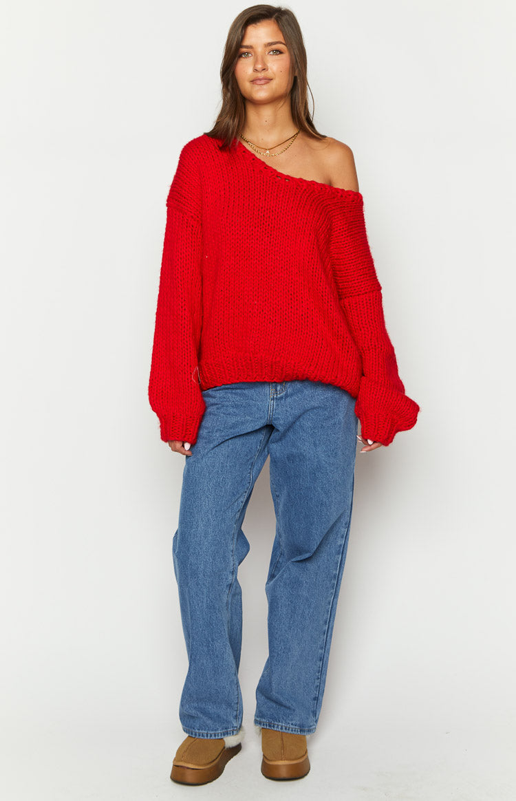Oversized red chunky knit sweater with a wide off-shoulder neckline and long, relaxed sleeves