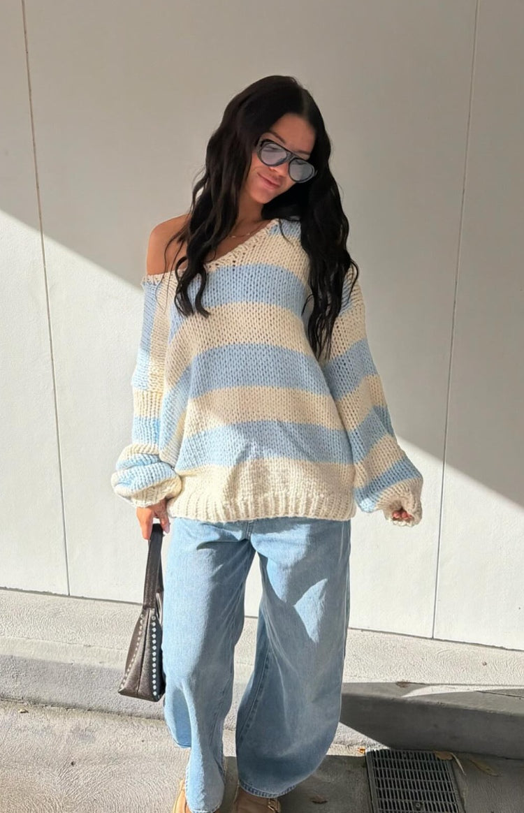 Light blue and cream striped chunky knit sweater with an oversized fit and V-neck worn off-shoulder