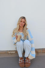 Light blue and cream striped chunky knit sweater with a wide scoop neck and relaxed oversized fit