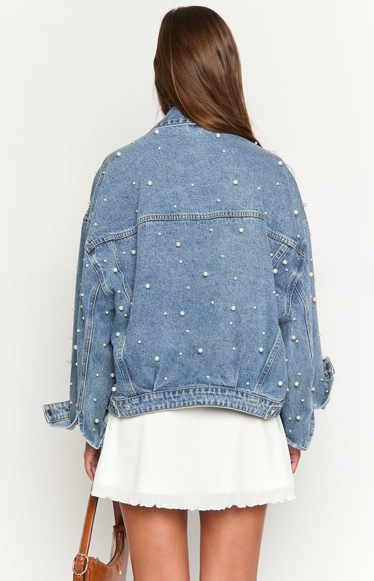 Rear view of a mid-wash blue denim jacket with an oversized fit and scattered pearl details