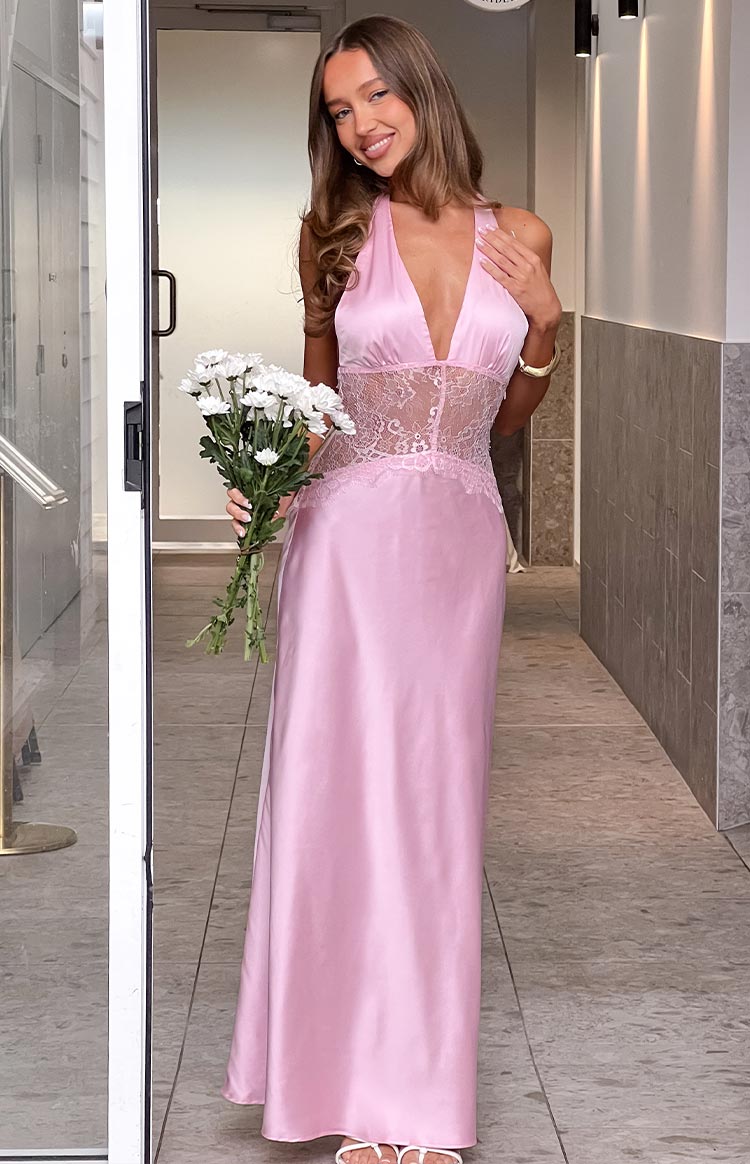 Front view of a pink satin halter neck maxi dress with a deep V-neckline and intricate lace panel on the bodice