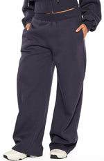 Navy barrel leg track pants with elasticated waistband, side pockets, and curved leg seam detail