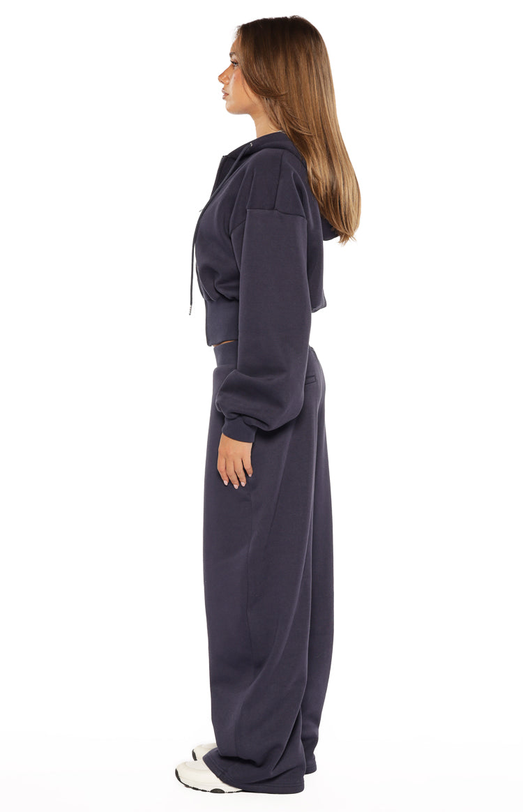 Side view of a navy cropped zip hoodie sweater with long sleeves and a drawstring hood