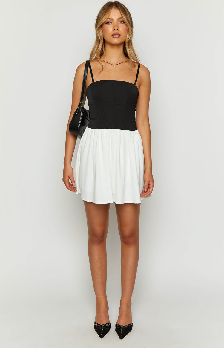 Black and white mini dress with a square neckline, thin straps, a structured black corset top, and a gathered white skirt