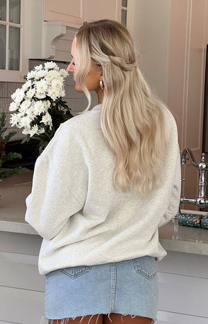 Rear view of an oat marle crew neck sweater showing the relaxed fit and dropped shoulders