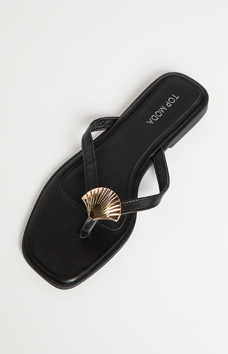 Top-down view of a black thong sandal with a gold shell embellishment on the toe post and square toe
