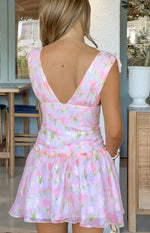 Rear view of a pink floral mini dress with a deep V-back, shoulder ties, fitted bodice, and a ruffled tiered skirt