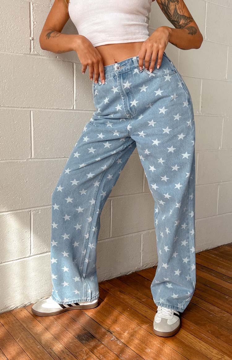 Full length view of the mid wash denim wide leg jeans with white star print, showing the relaxed fit and hem