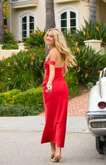 Rear-side view of a red off-shoulder formal dress with a fitted bodice and flowing skirt