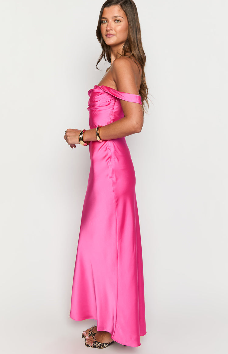 Side view of a hot pink satin off-shoulder formal dress with a draped neckline and flowing skirt