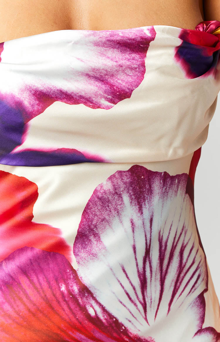 Close-up of the large pink and purple floral print on the cream satin dress, showing side ruching and knot detail