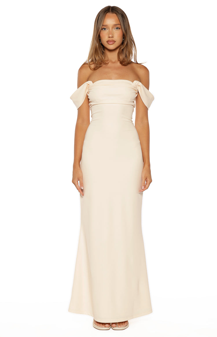 Front view of a cream crepe maxi dress featuring an off-shoulder ruched bandeau neckline and short draped sleeves