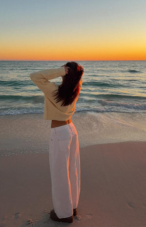 Back and side view of white denim barrel leg jeans, showing the wide, curved leg and back pockets