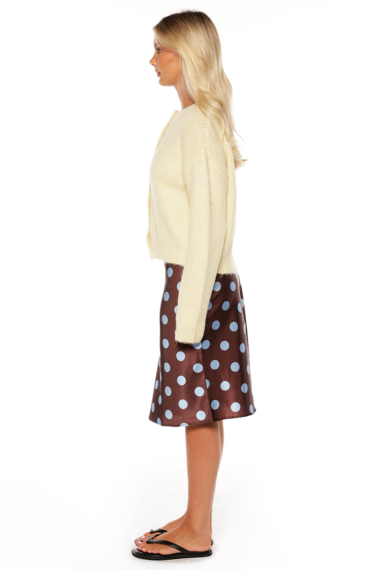 Side view of a butter yellow knitted cardigan with a relaxed fit, long sleeves, and ribbed cuffs