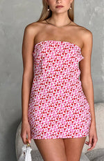 Front view of a white strapless mini dress with an all-over pink and red speckled pattern and a fitted silhouette
