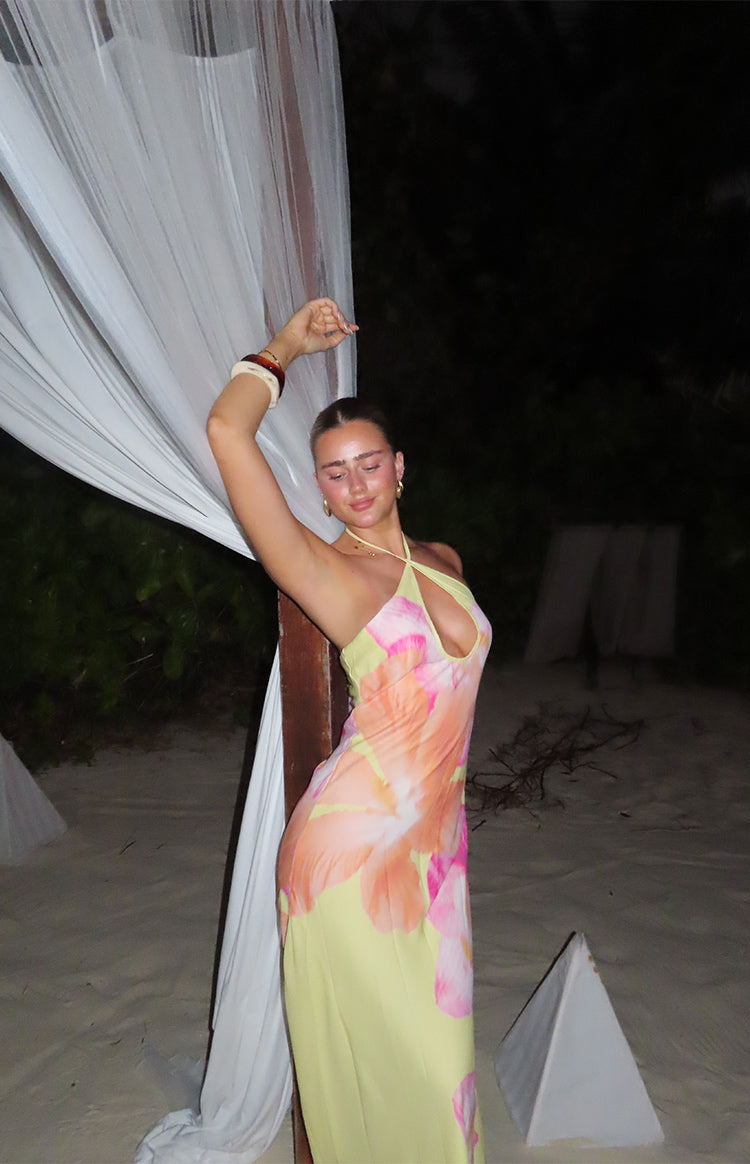 Yellow hibiscus floral halter maxi dress with a deep keyhole cutout and a flowing skirt