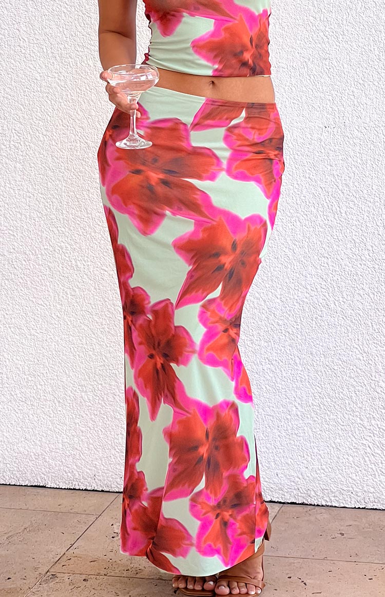 Fitted green maxi skirt with large pink and red floral print, showing the bodycon silhouette