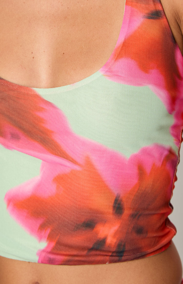 Close-up of the light green mesh halter top with scoop neckline and vibrant pink and orange floral print