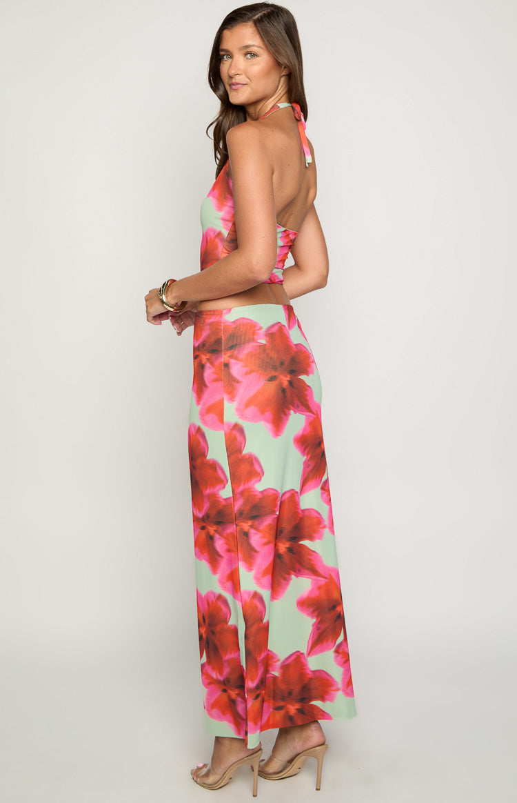 Side view of the green maxi skirt with large pink and red floral print and flowy fit