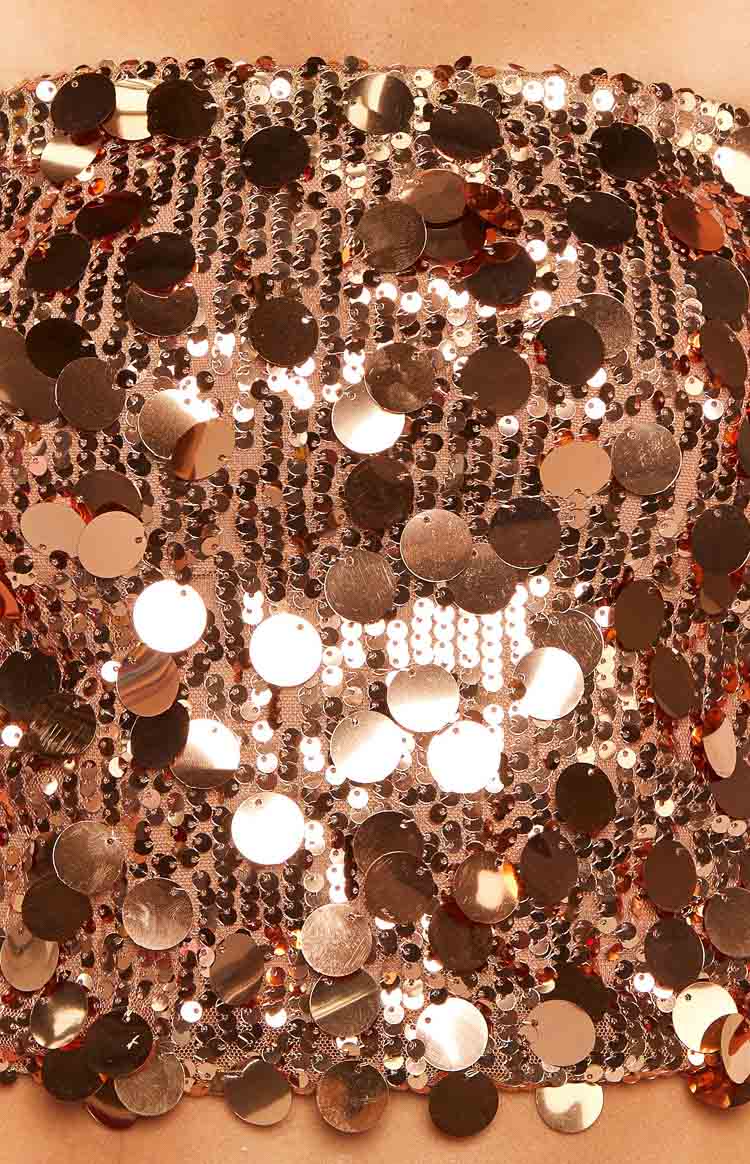 Close-up of the bronze sequin fabric with varying sizes of round, reflective sequins