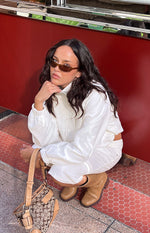 Cream funnel neck sports jacket with elasticated cuffs and hem, showing a relaxed cropped fit