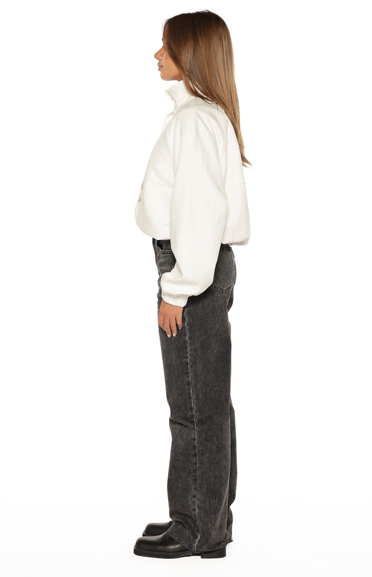 Side view of a cream funnel neck sports jacket with a cropped, relaxed fit and ribbed cuffs
