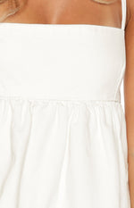 Close-up of the white denim top's square neckline, thin straps, and gathered babydoll waist seam
