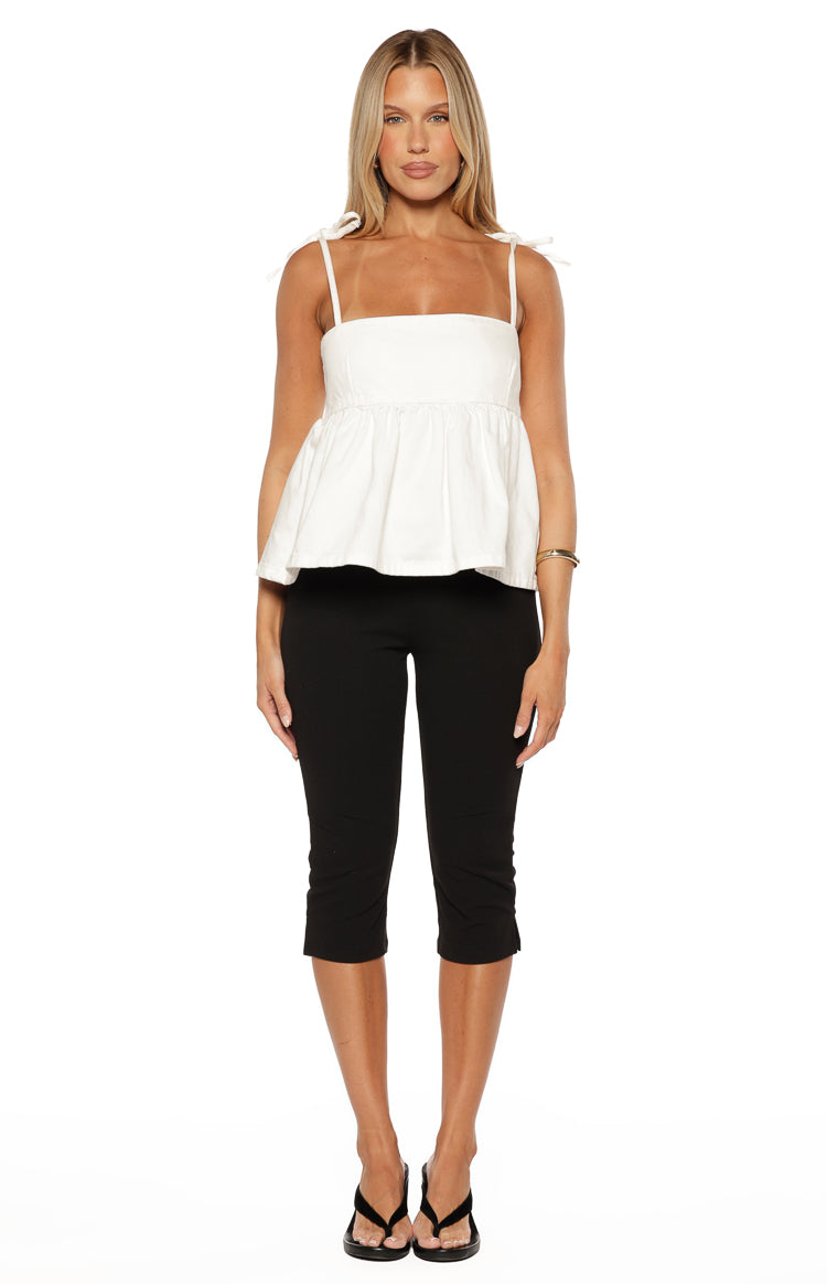 Front view of a white denim top with a square neckline, tie-up spaghetti straps, and a flared peplum hem