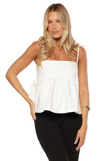 White denim top with a square neckline, tie shoulder straps, and a gathered peplum hem