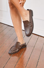 Brown leather slip-on loafers featuring a backless design and classic penny strap